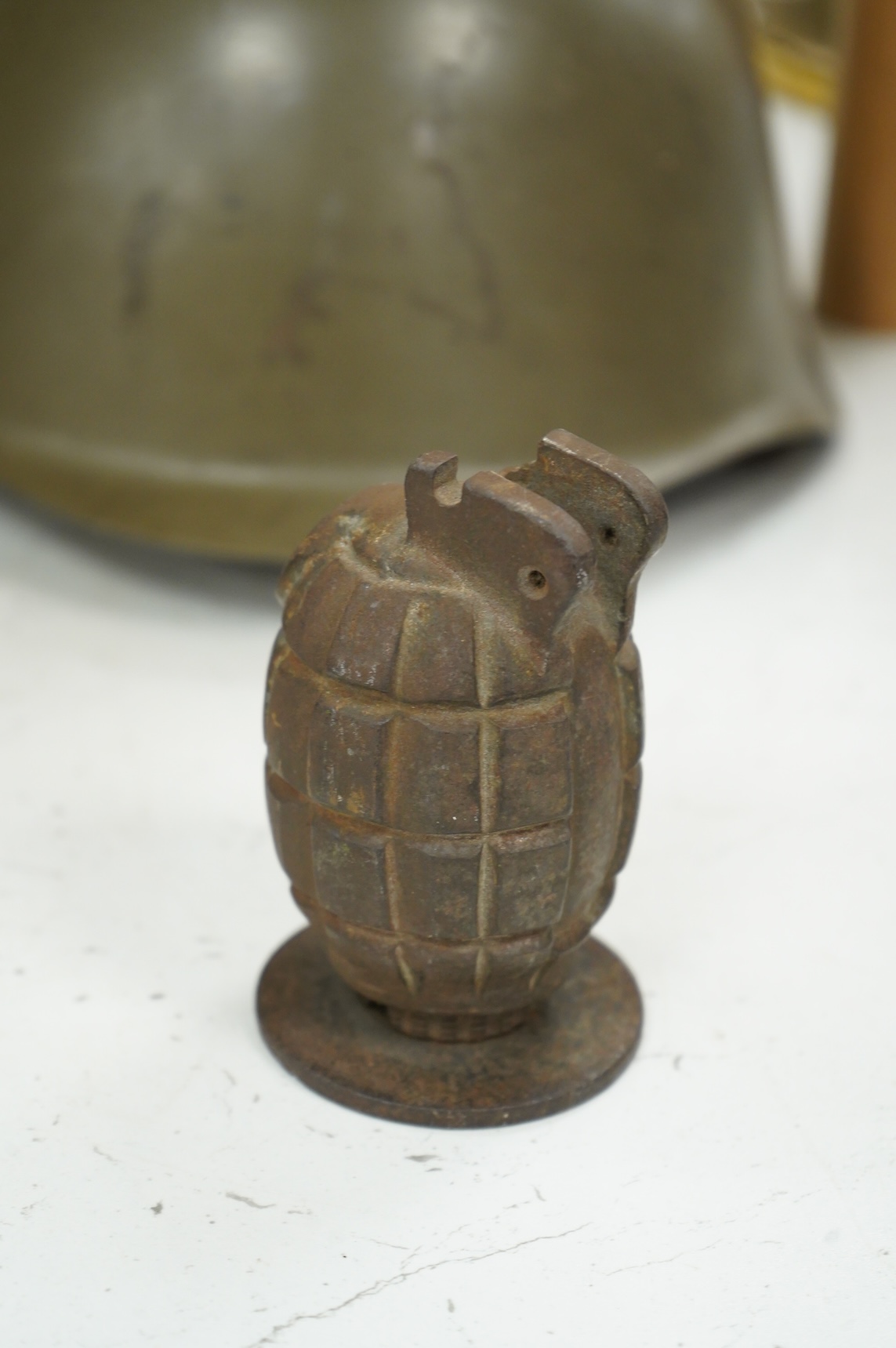 A Czech Vz53 tin helmet with liner, a Kris with applied presentation plaque engraved with ‘Presented by 'C' Battery’ and an inert British Mills hand grenade